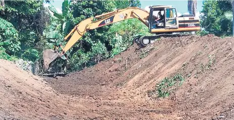  ??  ?? DESAGÜE. Maquinaria contratada por la alcaldía trabaja en el dragado del canal que permite la salida del agua al río Chamelecón.