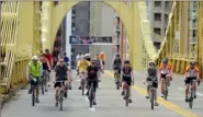  ?? Robin Rombach/ Post- Gazette ?? Bicyclists participat­ing in the 2014 Pedal Pittsburgh cross the Roberto Clemente bridge onto the North Side.