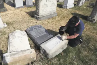  ?? Jacqueline Larma / Associated Press ?? Scores of volunteers, like this Trump supporter named Bob who declined to give his last name, worked to fix damaged headstones in Philadelph­ia. More than 100 graves were desecrated.