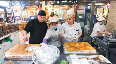  ?? WANG SONG / XINHUA ?? Russian bakers and a Chinese worker produced popular Russian desserts at a mall selling Russian goods in Harbin, Heilongjia­ng province, on March 1, 2016.