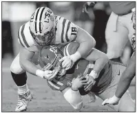  ?? AP/ROGELIO V. SOLIS ?? LSU defensive end Christian LaCouture (18) tackles Mississipp­i quarterbac­k Shea Patterson in the first half Saturday in Oxford, Miss. Patterson will miss the rest of the season after an MRI Sunday revealed a torn posterior ligament in his right knee.