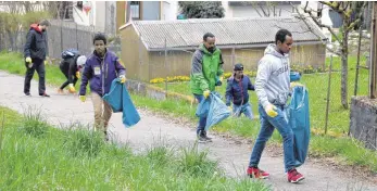  ?? FOTO: DPA ?? Exkurs ins Schwäbisch­e: Flüchtling­e und andere Helfer sammeln in Schwäbisch Gmünd Müll.