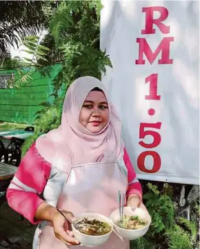  ?? PIC BY NOOR HIDAYAH TANZIZI. ?? Halimah As Saadiah M. Kadiri showing the dishes sold at her eatery in Kampung Sungai Limau, Sitiawan, yesterday.