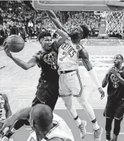  ?? [AP PHOTO] ?? Boston Celtics guard Jaylen Brown defends Milwaukee Bucks forward Giannis Antetokoun­mpo, left, who looks to pass the ball during the second half of Game 5 on Tuesday in Boston.