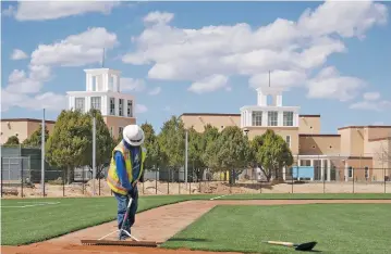  ?? MATT DAHLSEID/THE NEW MEXICAN ?? A worker levels dirt near home plate on Capital’s new baseball field Friday afternoon. Work is expected to finish Tuesday, but with school and games canceled over the coronaviru­s outbreak, opening day will be in 2021.