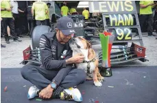  ?? FOTO: STEVE ETHERINGTO­N/IMAGO IMAGES ?? Lewis Hamilton feiert mit seiner Bulldogge Roscoe.