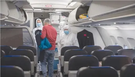  ?? ( Nati Shohat/ Flash90) ?? ISRAIR FLIGHT attendants wear full protective gear as they help a passenger disembark in Belgrade earlier this month.