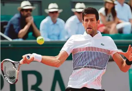  ?? AFP PIC ?? Novak Djokovic returns a shot to Joao Sousa in the second round of the French Open at Roland Garros yesterday.