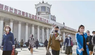  ?? Reuters-Yonhap ?? People wearing protective face masks walk amid concerns over COVID-19 in front of Pyongyang Station in Pyongyang, North Korea in this April 27, 2020 file photo released by Kyodo.