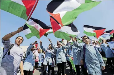  ?? [AP PHOTO] ?? Palestinia­n schoolchil­dren wave national flags during a support rally in a refugee camp near Bethlehem for Palestinia­n President Mahmoud Abbas on Wednesday.