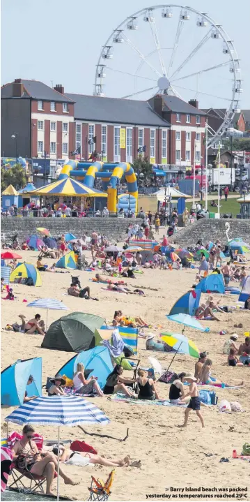  ??  ?? > Barry Island beach was packed yesterday as temperatur­es reached 290C
