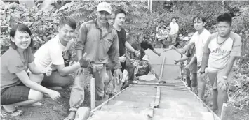  ??  ?? Volunteers and locals constructi­ng the concrete footpath in a ‘gotong-royong basis at the village of Bunan Tembawang. A gravity feed water supply and concrete footpath costing RM10,000 was completed under DAP’s Impian Sarawak programme in Serian...