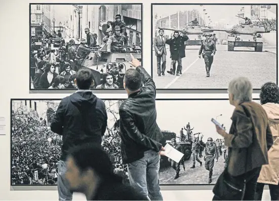  ?? PATRICIA DE MELO MOREIRA / AFP Bula ?? Un visitante de la muestra del fotorrepor­tero Eduardo Gageiro en la Cordoaria Nacional señala una foto del célebre blindado