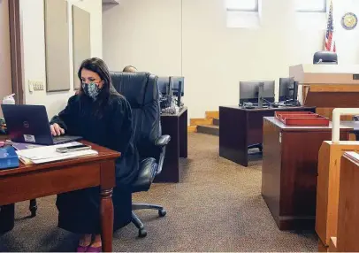  ?? Photos by Kin Man Hui / Staff photograph­er ?? Judge Jackie Valdés works on her laptop inside the courtroom. The first-time jurist is following in her mother’s footsteps.