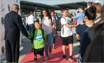  ?? RECORDER PHOTO BY CHIEKO HARA ?? Walking down the red carpet, new and returning students at Summit Charter Collegiate Academy are welcomed by staff members and Principal Jorge Robles Thursday on the first day of school.