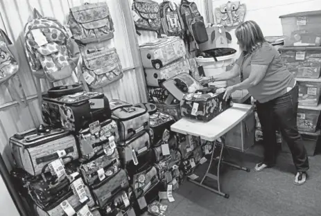  ?? Helen H. Richardson, The Denver Post ?? Allison Drexel, a Denver Public Schools liaison for the Every Student Succeeds Act, gathers bags filled with new items to be given to foster children. The bags, customized for girls and boys, include a pillow, pillowcase, soft blanket, pair of pajamas,...