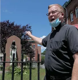  ??  ?? LET’S TALK: The Rev. John Currie, left and above, leaned over to touch the statue and said a prayer for the person responsibl­e, saying the church is willing to help them.