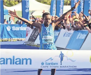  ??  ?? THAT SWEET WINNING FEELING: Ethiopia’s Asefa Mengistu Negewo and Betelhem Moges Cherenet burst through the tape to take the honours in the Cape Town Marathon yesterday.