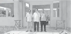  ??  ?? Harden (centre), flanked by Waterkille­r (left) and Deniel in front of the Kampung Muhibbah multipurpo­se hall, which is still under constructi­on.