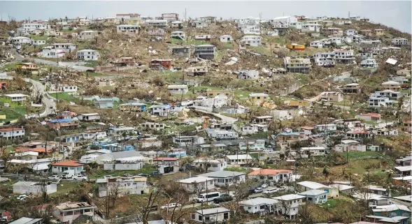  ??  ?? Damaged houses line a hillside in Old Tutu following Hurricane Irma in St. Thomas in the U.S. Virgin Islands.