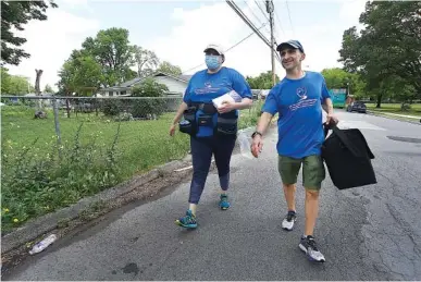  ?? STAFF PHOTO BY MATT HAMILTON ?? Nurse Allessandr­a Vitrano, left, and Dr. Matthew Kodsi, vice president of medical affairs at CHI Memorial, walk through a neighborho­od near East Lake Park in July. The two went door-to-door to inform residents of a block party going on in the park which offered the COVID-19 vaccines. The two also brought doses of the Johnson & Johnson vaccine with them to vaccinate any residents who were interested.