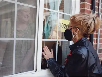  ?? Yehyun Kim / CTMirror.org ?? Kathy Moore, left, talks to her sister-in-law Ann Marie Lagrange, of Windsor Locks, through the window at Manchester Manor Health Care Center.