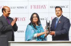  ?? Ahmad Ramzan/ Gulf News ?? Mrinal Shekar (centre), Editor, Friday, and Anand Raj OK (left), Features Editor, present trainer Satish Seemar with the Friday Trophy. Seemar’s Lavaspin, a horse purchashed out of the Dubai Horse Sales, won the contest.