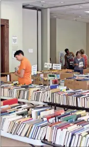  ??  ?? Locals look through the selection of books at the Friends of the Library Book Sale at the Rome-Floyd County Library on Monday.