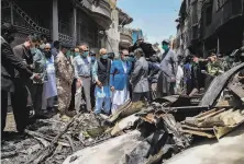  ?? Pakistan Civil Aviation Authority ?? Imran Ismail (center in blue), the governor of Sindh province, examines debris from the jetliner crash in Karachi.