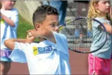  ??  ?? Six‑year‑old Deven Vennera practices his backhand during a Greater Pottstown & tennis clinic.