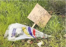  ?? Heather Knight / The Chronicle ?? Payal Gupta left a bouquet of flowers and a sign at the median on Webster and Bush streets, where the man died.