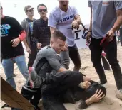  ?? — AP ?? A supporter of President Donald Trump (centre) clashes with an anti-Trump protester in Huntington Beach, California, on Saturday.