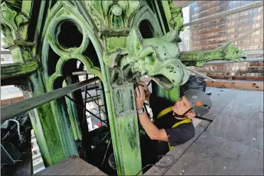  ?? MARY ALTAFFER/AP PHOTO ?? Gabriel Popian, vice president of G & L Popian Inc., works on a gargoyle detail Thursday while restoring a copper spire as part of the ongoing $177 million restoratio­n of St. Patrick’s Cathedral in New York. The renovation, done in three phases over...