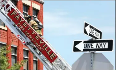  ?? NWA Democrat-Gazette/DAVID GOTTSCHALK ?? Members of the Fayettevil­le Fire Department respond July 7 to the report of smoke in a building in downtown Fayettevil­le. The smoke was the result of working being done in the building.