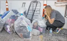  ??  ?? Former resident Ashley Rogers reacts to what she finds Thursday inside a bag of possession­s from her and her mother’s room in the Alpine Motel Apartments, which burned in a Dec. 21 fire.