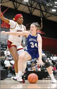  ?? (Courtesy of Parker Waters) ?? John Brown forward (34) Tarrah Stephens dribbles around Loyola University forward Liz Critton in the NAIA national tournament on March 7, 2023, in New Orleans. Stephens became JBU’s all-time leading scorer on Feb. 3 when she scored her 2,035th point.