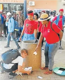  ?? Picture: SCREENGRAB FROM TWITTER/@NONNYSTONE­D ?? START TALKING: University of the Free State student Eckhard Binding carries on throwing rubbish in a bin as women in EFF T-shirts throw it out on Friday