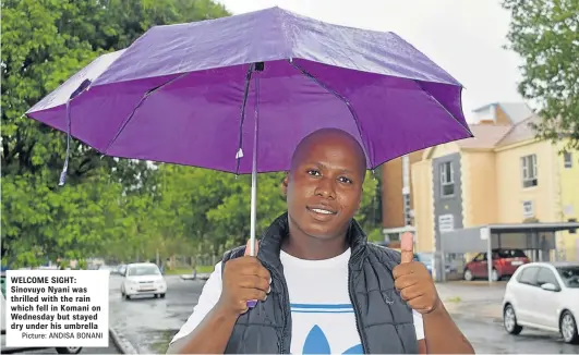  ?? Picture: ANDISA BONANI ?? WELCOME SIGHT: Sinovuyo Nyani was thrilled with the rain which fell in Komani on Wednesday but stayed dry under his umbrella