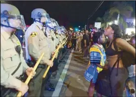  ?? AP ?? Demonstrat­ors yell at police during a protest in El Cajon, California Wednesday. Dozens of activists protested the killing of Alfred Olango, a Ugandan refugee shot by an officer.