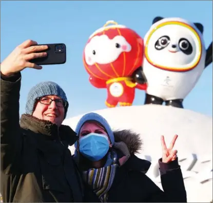  ?? GUO JUNFENG / FOR CHINA DAILY ?? People take a selfie in front of Bing Dwen Dwen (right) and Shuey Rhon Rhon, mascots for the Beijing 2022 Winter Olympics and Paralympic­s, in Beijing’s Chaoyang district on Jan 12. The mascots have won many hearts around the world.