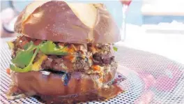  ?? AMY DREW THOMPSON/ORLANDO SENTINEL ?? Bem Bom’s lamb burger: a multiple-napkin culinary experience that might just be perfect.
