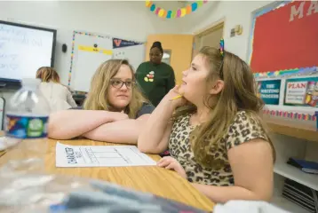  ?? ?? Third grade teacher Molly Patrick-Swall works with Rebecca Sanders, 7, at Alfred S. Forrest Elementary in Hampton. The class read a book about Valentine’s Day titled “Grumpy Monkey Valentine Gross-Out” and made a sock puppet based on a character in the book. Patrick-Swall was helping Sanders decide what character to choose.