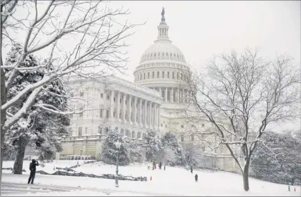  ?? Joshua Roberts / Bloomberg ?? Sledders enjoy the snowfall on Sunday at the U.S. Capitol in Washington, D.C. Sunday was the 23rd day of the government shutdown, which this weekend became the longest shutdown in U.S. history.