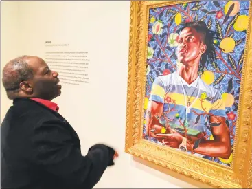  ?? Joe Amarante / Hearst Connecticu­t Media ?? Frank Mitchell, executive director of the Amistad Center for Art & Culture, discusses Kehinde Wiley’s vivid “Portrait of Taks Adewetan (The King of Glory),” 2016.