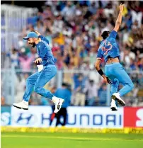  ?? PTI ?? Kohli (left) and Pandya celebrate the wicket of Smith. —