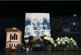  ?? GRANT HINDSLEY — SEATTLEPI.COM VIA AP ?? Flowers and cards sit in front of a large image with a depiction of Chris Cornell on it during a memorial for Cornell on Thursday in Seattle. Cornell, one of the most lauded and respected contempora­ry lead singers in rock music with his bands...