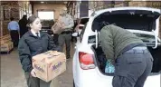  ?? ?? Kern County Sheriff’s Deputy Jeremy Bethell, Cadet Capt. Isbeth Mendivil and Kern County sheriff’s deputy aide Anna Abbott load up the cars Tuesday during a joint operation. BPD and KCSO distribute­d 400 boxes of food to families in need across Kern County for the 38th year.