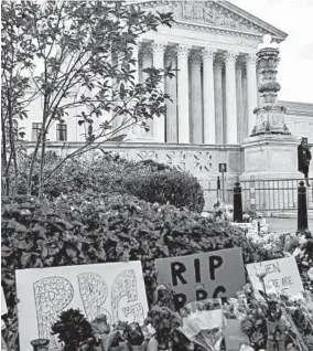  ?? JASON ANDREW/THE NEW YORK TIMES ?? Signs, candles and flowers are left outside the Supreme Court building on Saturday in Washington, D.C.