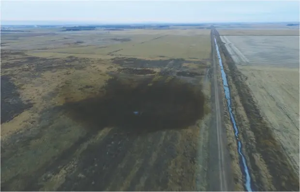  ?? DRONEBASE / REUTERS FILES ?? An aerial view shows the darkened ground of a 2017 oil spill that shut down the Keystone pipeline near Amherst, S.D.