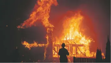  ?? ASSOCIATED PRESS FILE PHOTO ?? A home burns in 2018 as the Camp Fire rages through Paradise, Calif. Experts say it’s hard to know if proactive shutoffs of power by Pacific Gas & Electric Co. are to thank for California’s mild fire season this year.